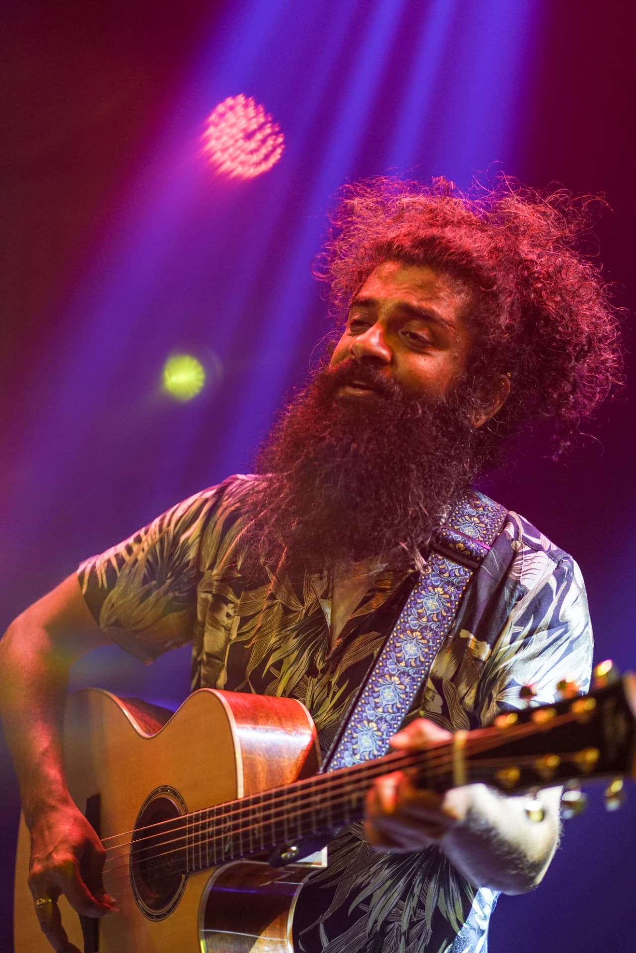 Vasu Dixit performing with a guitar on stage